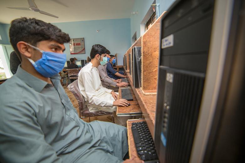 4 men sitting at computers