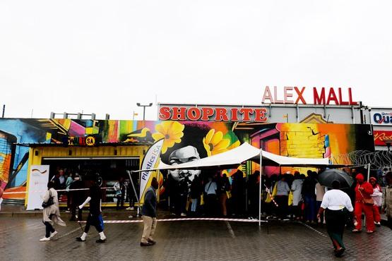 People walking and waiting in line in front of "ALEX MALL"