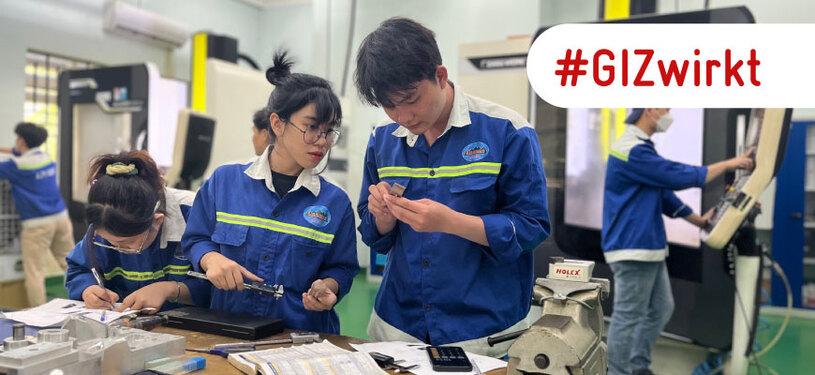Ein junger Mann sitzt über elektronische Schaltkreise gebeugt.