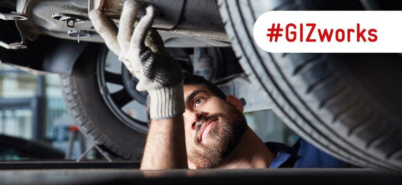 A vehicle mechanic repairing a car exhaust