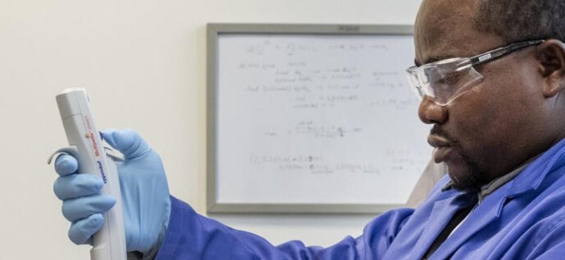 Ein Mann im Labor hält ein Messgerät in der Hand.