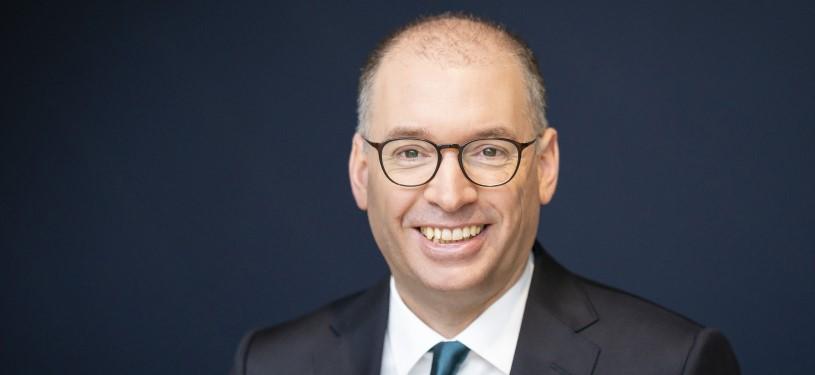 Portraitfoto von Niels Annen, Staatssekretär im Bundesministerium für wirtschaftliche Zusammenarbeit und Entwicklung, in dunklem Anzug mit petrolfarbener Krawatte