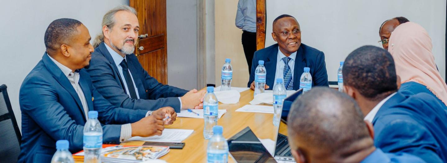 Menschen aus verschiedenen Ländern sitzen gemeinsam an einem Konferenztisch.
