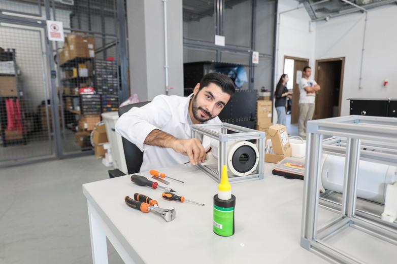 Ein Mann schraubt in einem IT-Unternehmen an einem Rechnerteil.