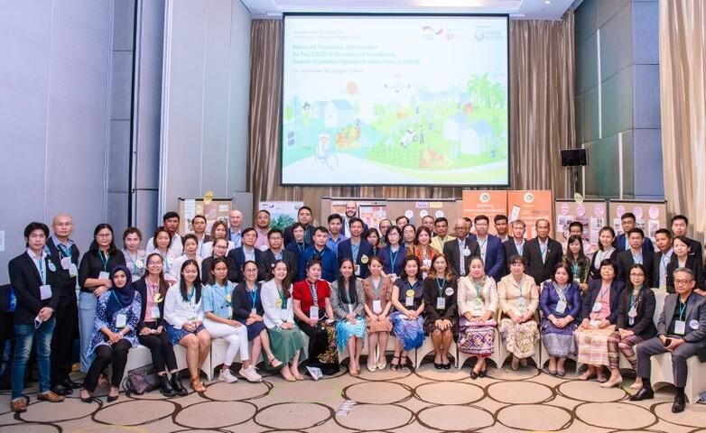 Eine größere Personengruppe vor einer Leinwand.