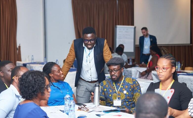 Mehrere Teilnehmende eines Trainings sitzen an einem Tisch und besprechen sich