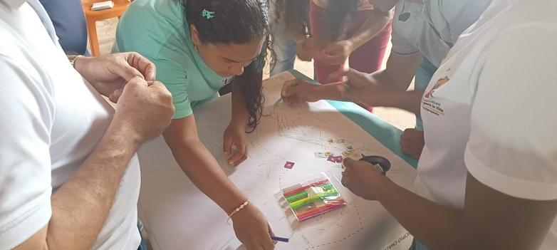 Zwei Frauen in einer Gruppe zeichnen eine Karte.