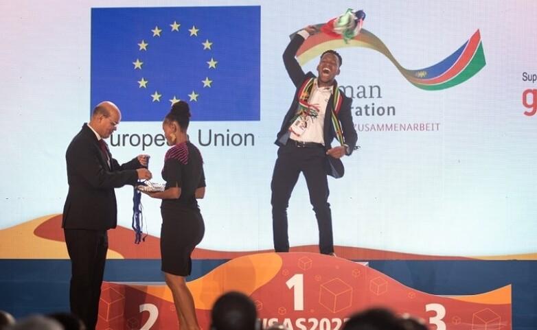 Ein Teilnehmer im WorldSkills Africa Wettbewerb nimmt seinen Preis entgegen.