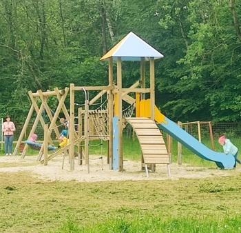 Auf einem Spielplatz mit Klettergerüst spielen mehrere Kinder.