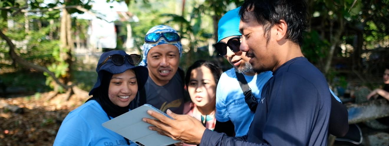 Gruppe von Menschen schaut gemeinsam auf ein Dokument