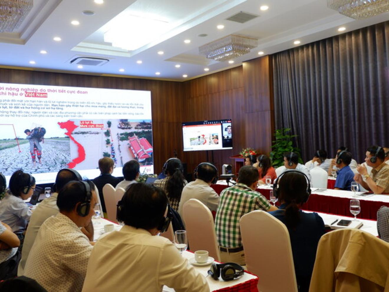 People sitting at tables listening to a presentation