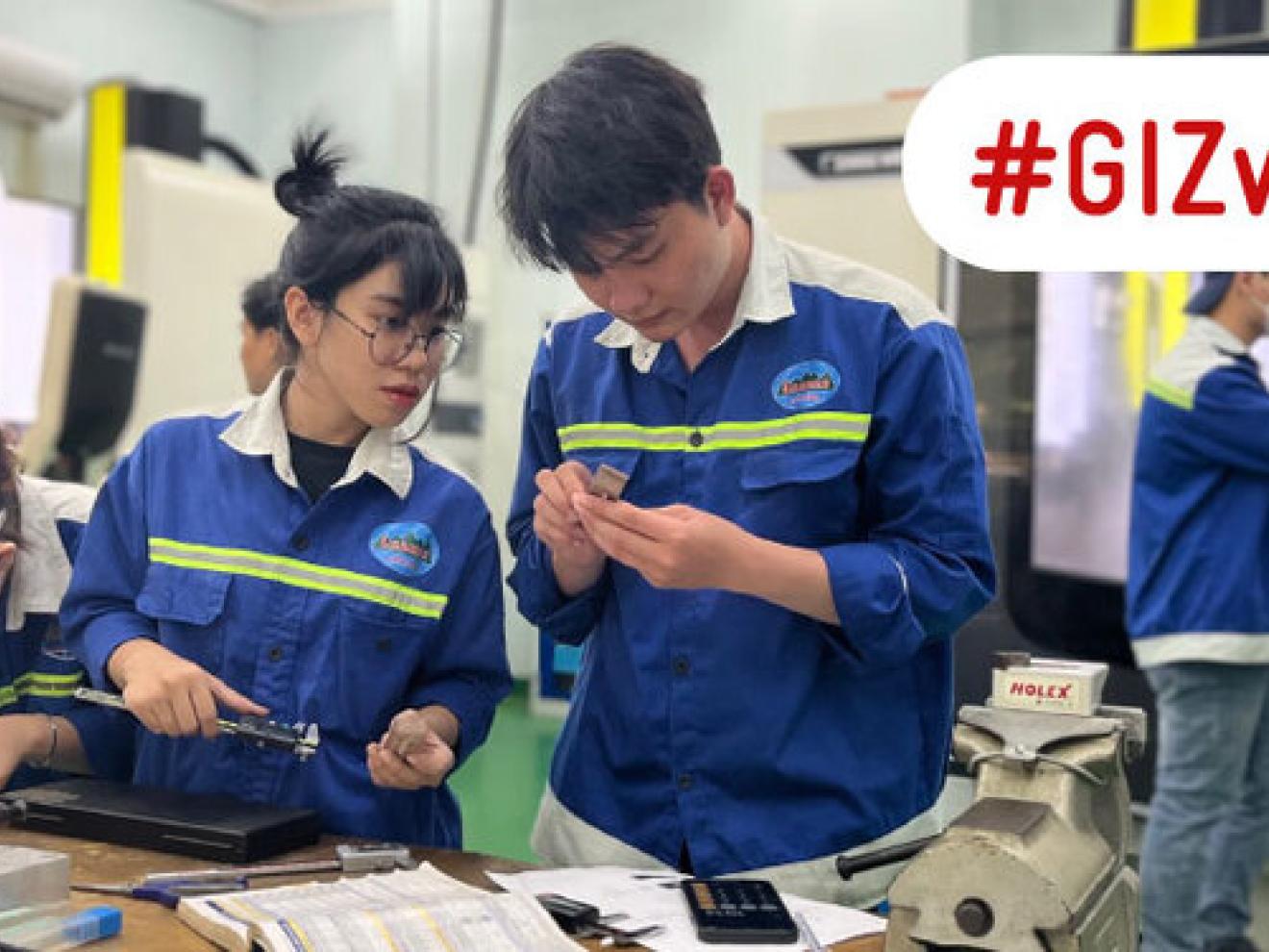 A young man sits bent over electronic circuits.