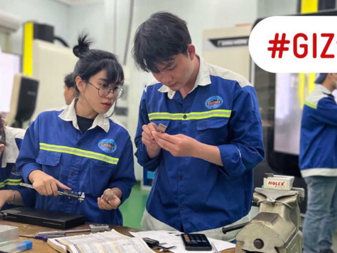 Ein junger Mann sitzt über elektronische Schaltkreise gebeugt.