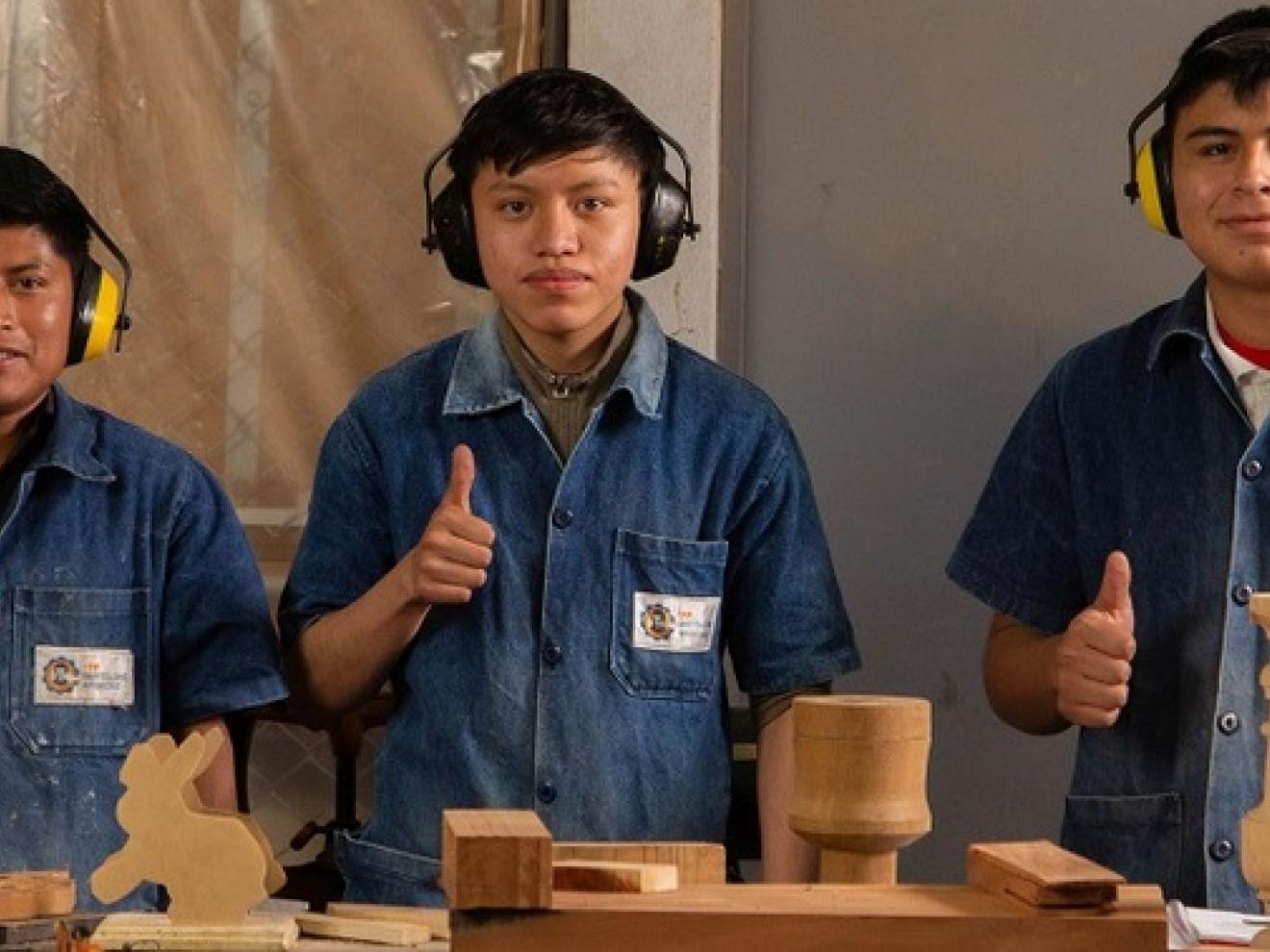 Eine Gruppe von Männern, die Kopfhörer tragen und Daumen nach oben zeigen.