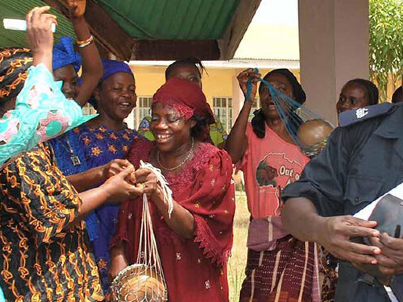 Ein Polizeibeamter ist von Frauen umringt.