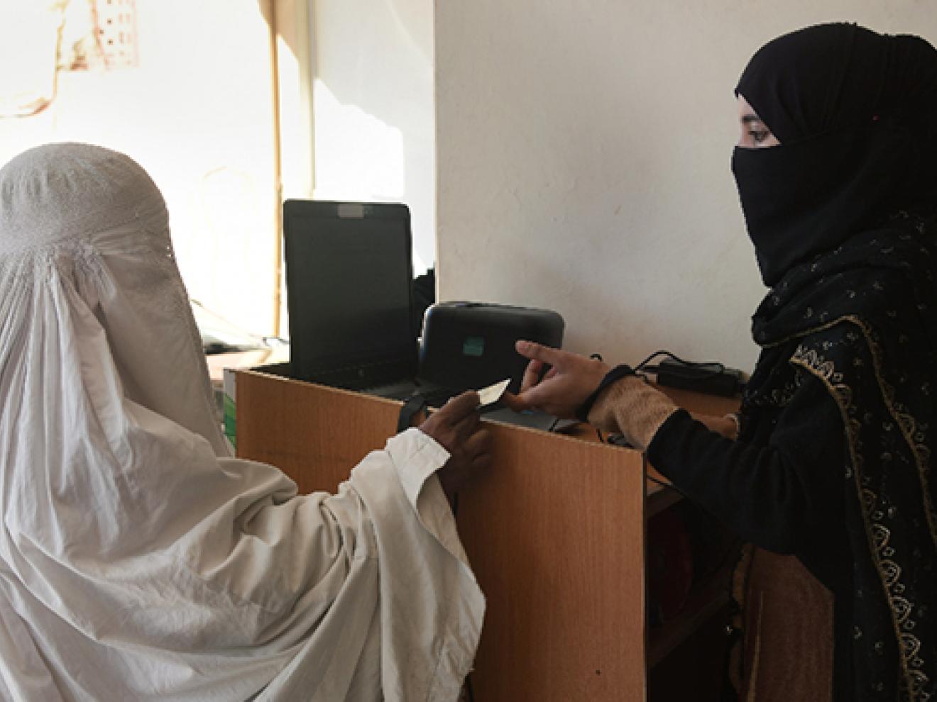 Zwei Damen in Burka an einem Tresen