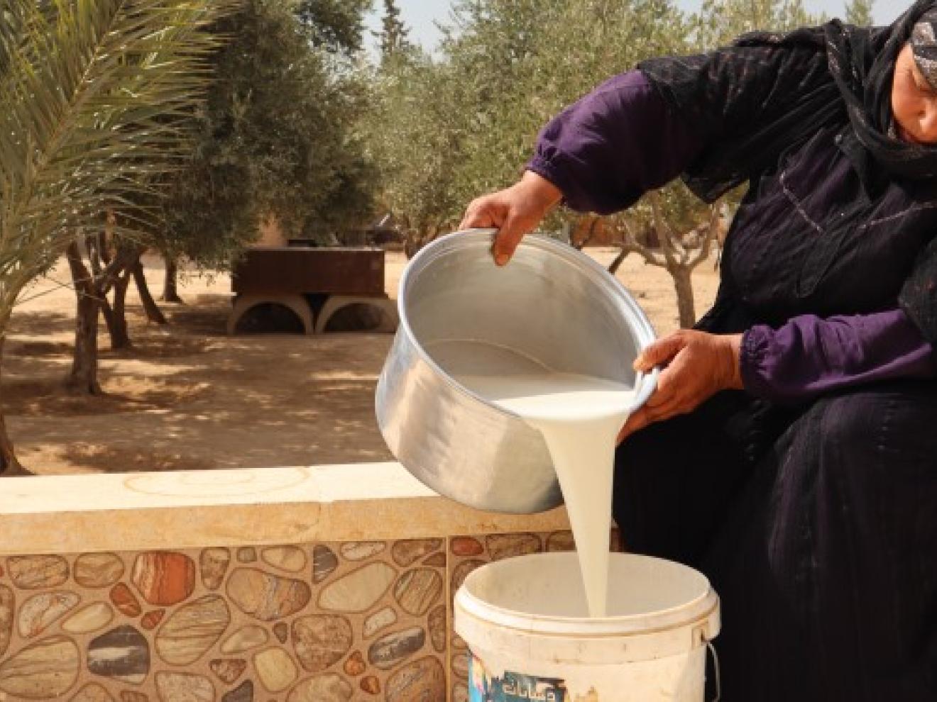 Eine Frau verarbeitet Milch, um sie besser haltbar zu machen.