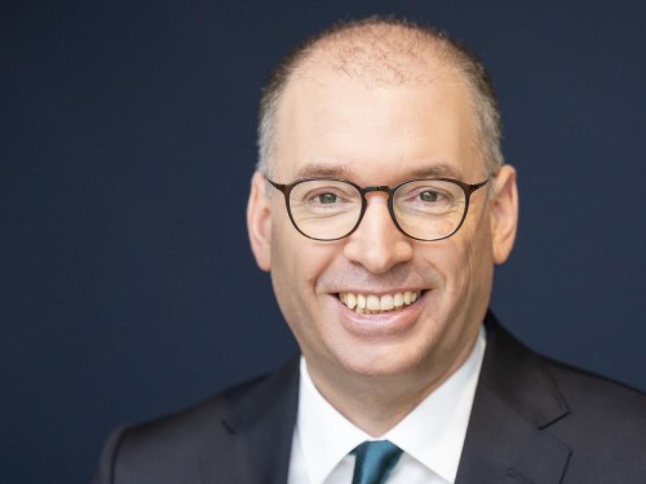 Portraitfoto von Niels Annen, Staatssekretär im Bundesministerium für wirtschaftliche Zusammenarbeit und Entwicklung, in dunklem Anzug mit petrolfarbener Krawatte