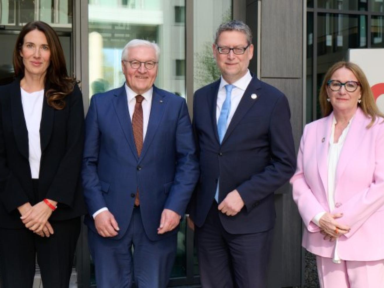 Vier Personen, einer davon Frank-Walter Steinmeier, stehen vor einem Gebäude.