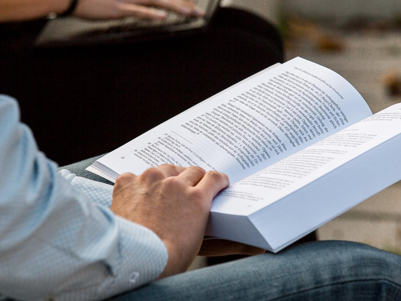 Person hält Buch in der Hand