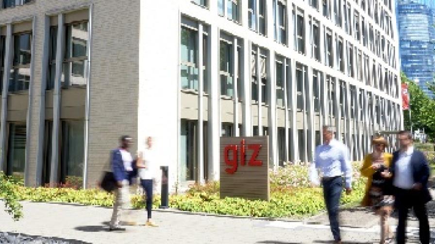 Personen in Bewegung vor dem GIZ Gebäude