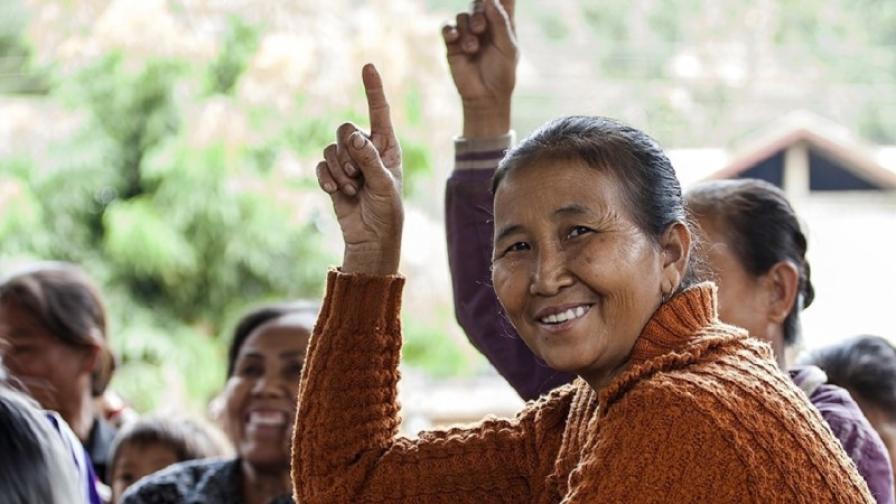 Frauen deuten mit ihrem Zeigefinger nach oben.